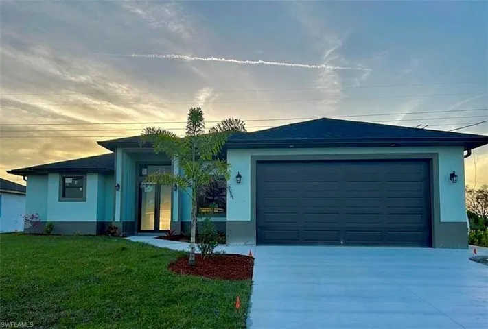Single story home with a garage and a yard