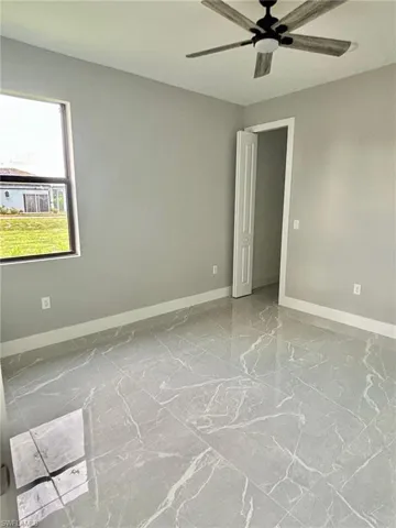 Tiled spare room with ceiling fan