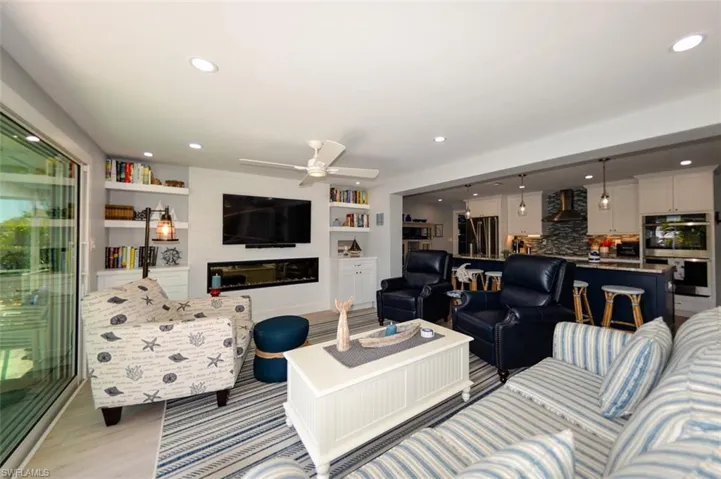 Living room featuring built in shelves, and ceiling fan