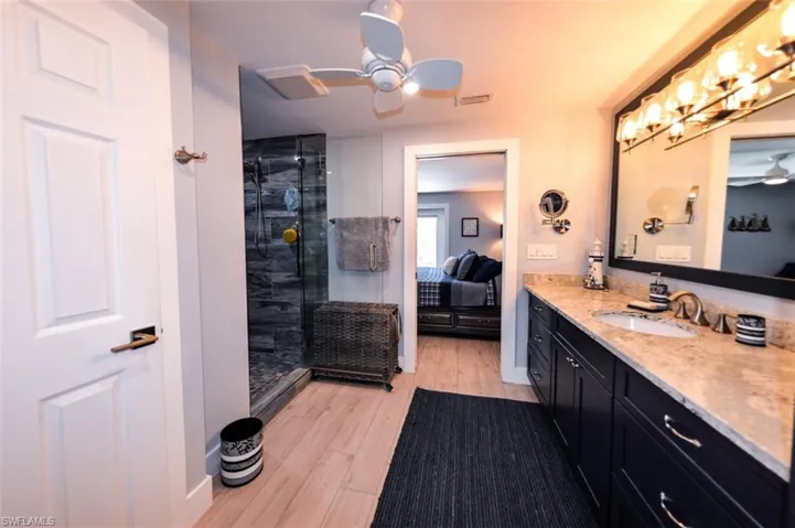 Bathroom vanity, ceiling fan, and a tile shower