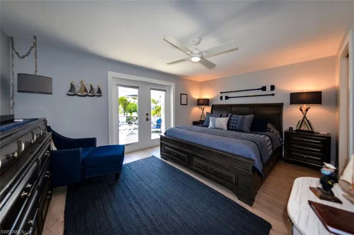 Primary bedroom featuring access to exterior with french doors to the pool, and ceiling fan