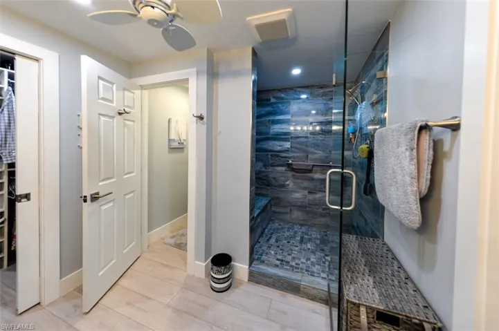 Bathroom featuring ceiling fan and walk in shower