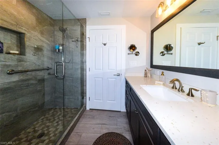 Bathroom featuring a shower with door and vanity
