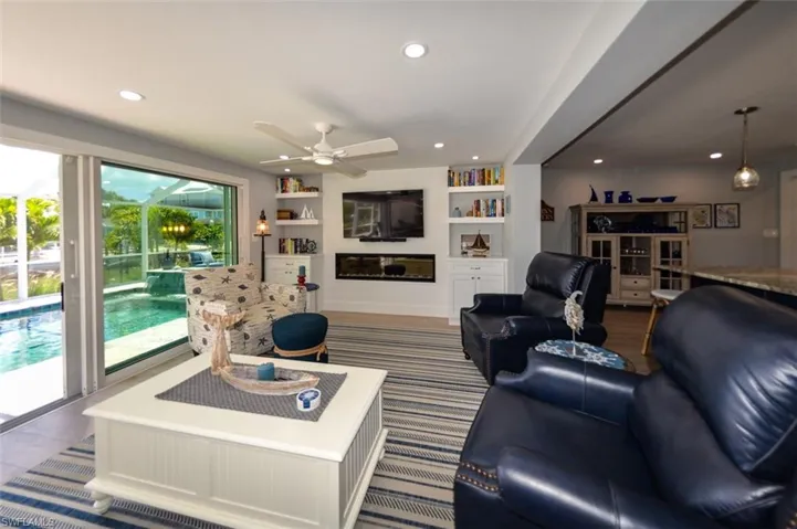 Living room featuring built in features and ceiling fan