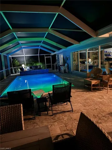 View of swimming pool featuring a patio and glass enclosure