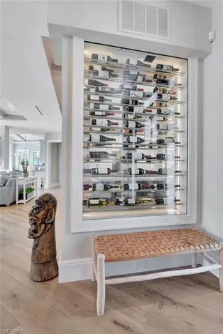 Wine area featuring light hardwood / wood-style floors and a notable chandelier