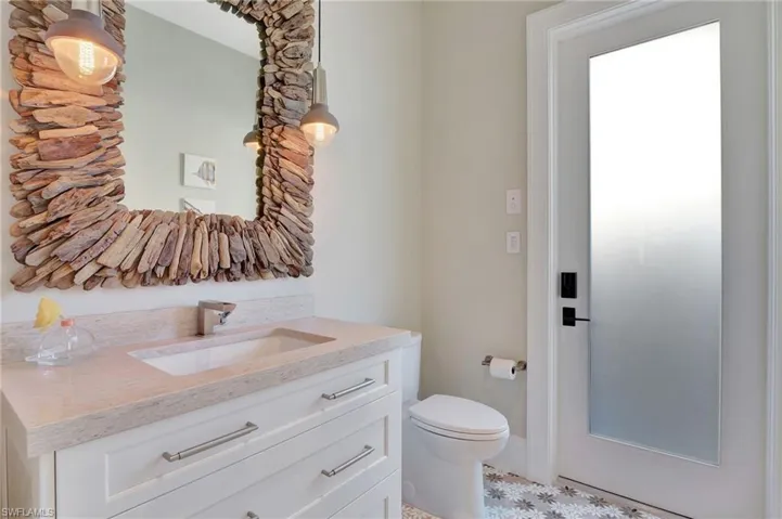 Guest Bathroom/Pool bath with exterior door to pool featuring toilet and vanity
