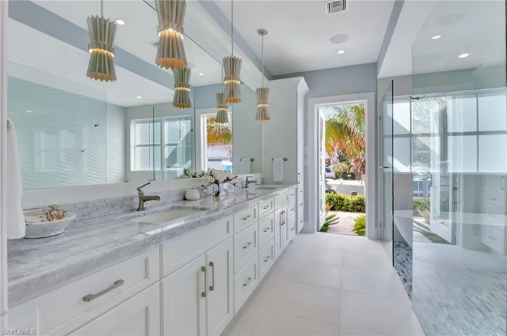 Primary bathroom off the private deck featuring vanity, an enclosed shower, tile patterned floors, and a wealth of natural light