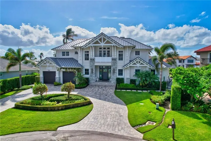 View of front of house with a balcony, a front lawn, and a garage