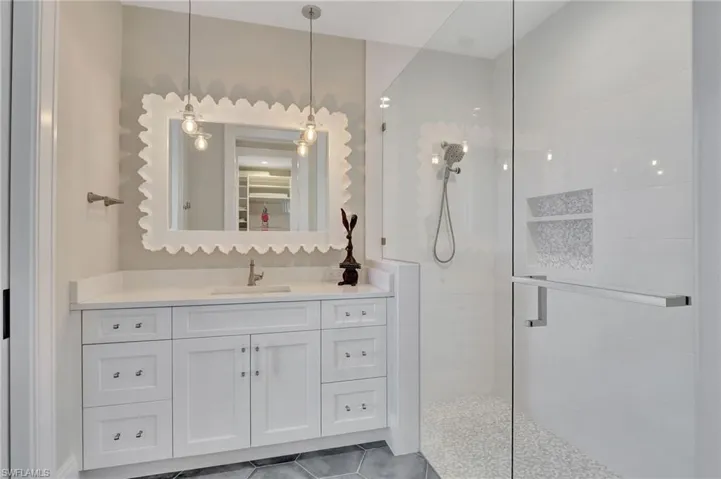 Bathroom featuring vanity, a shower with shower door, and tile patterned flooring