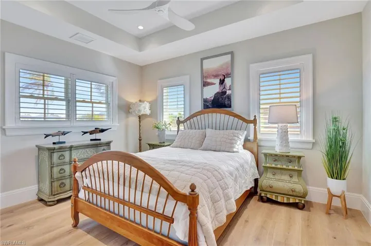 Bedroom featuring light hardwood flooring, multiple windows, and ceiling fan