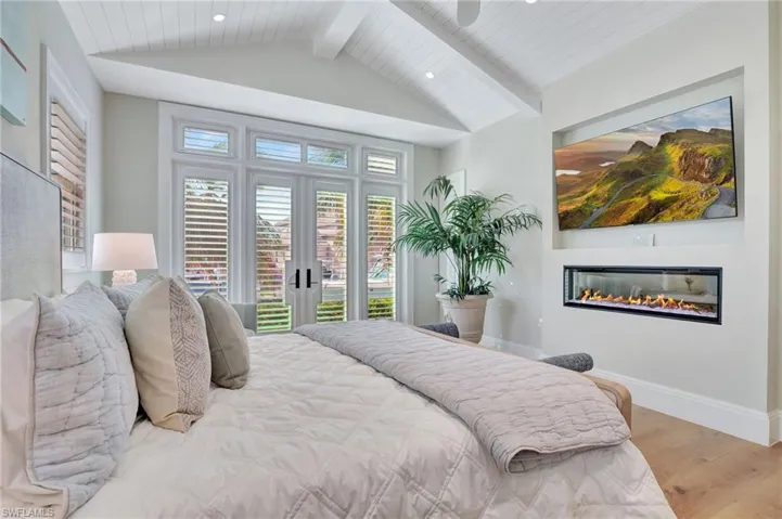 Bedroom with light hardwood / wood-style flooring, wood ceiling, access to exterior, and lofted ceiling with beams