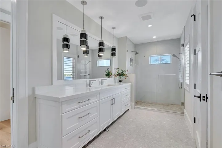 Bathroom with double faucet vanity and walk in shower