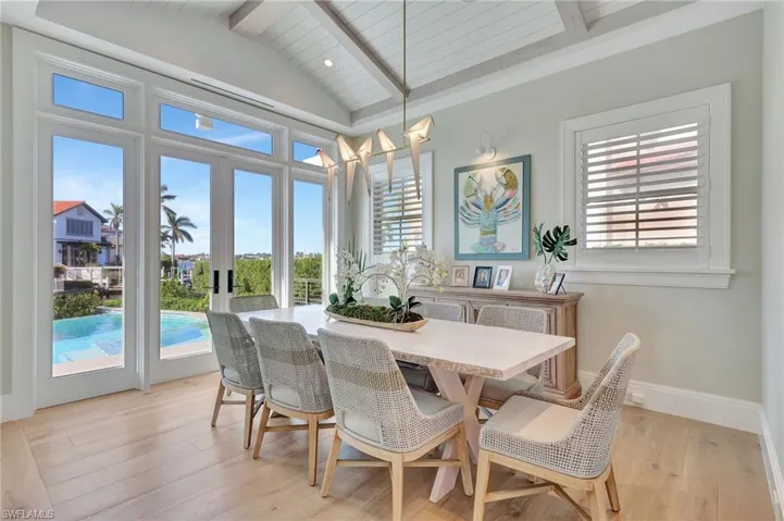 Dining room with french doors, light hardwood flooring, lofted ceiling with beams, and wooden ceiling
