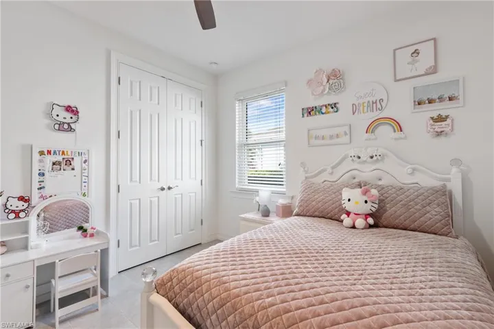 Tiled bedroom with ceiling fan and a closet