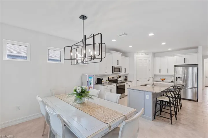Tiled dining room with a chandelier and sink