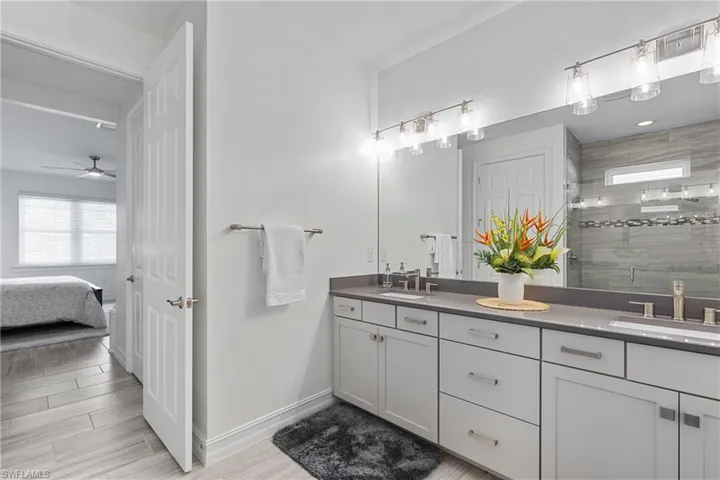 Bathroom with vanity, a shower with door, and ceiling fan