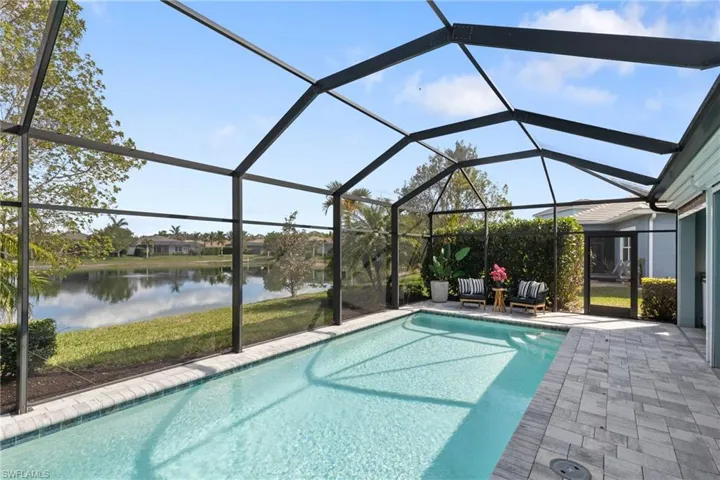 View of swimming pool featuring a lanai, a patio, and a water view