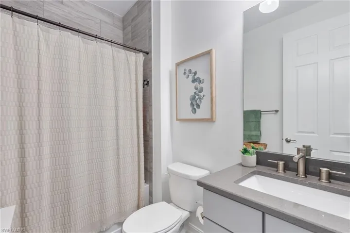 Full bathroom with vanity, toilet, and shower / tub combo with curtain