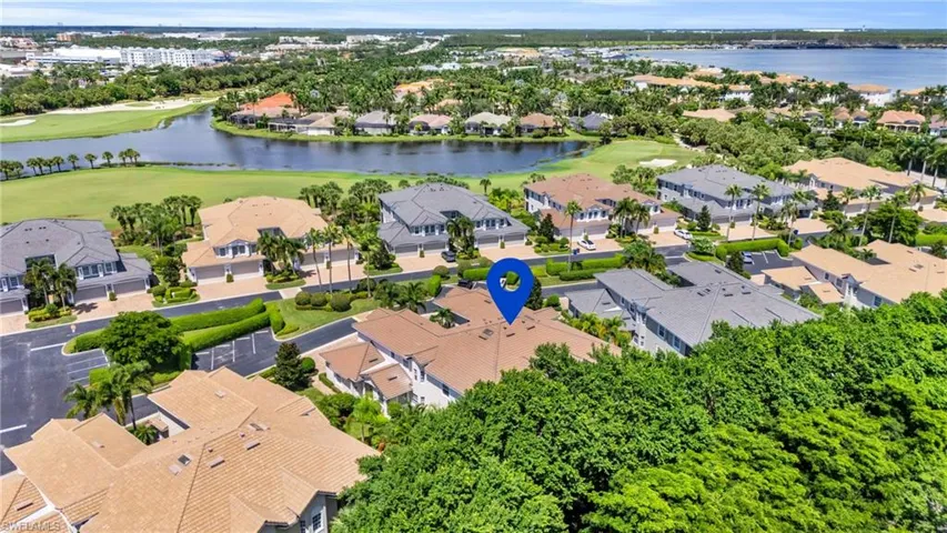 Aerial view of residential area with a local golf course and a nearby body of water