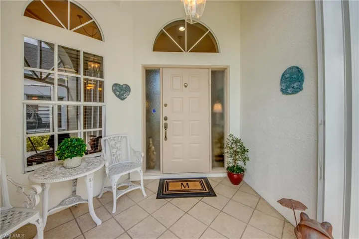 Tiled under truss front entry protected with shutters.