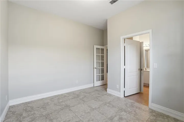 Unfurnished bedroom with light tile patterned flooring and ensuite bath
