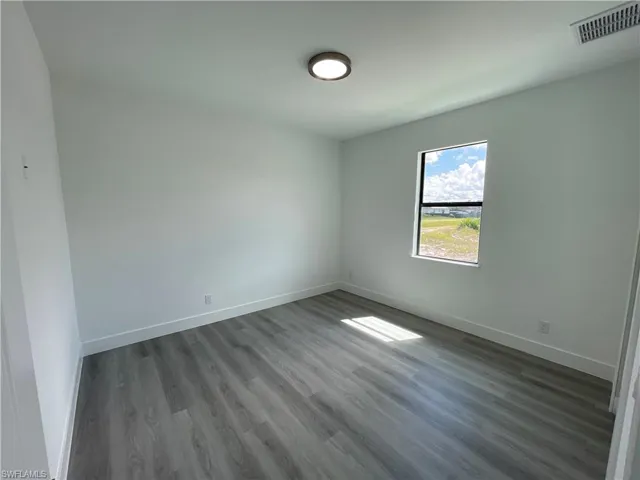 Unfurnished room featuring wood finished floors and baseboards