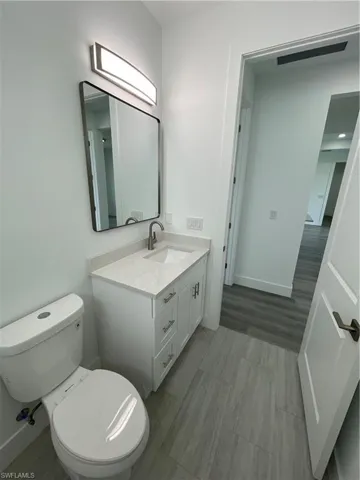 Half bathroom featuring vanity and toilet