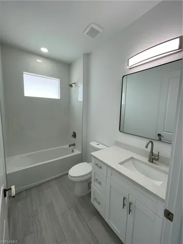 Full bath with shower / bath combination, vanity, and recessed lighting