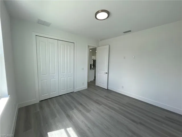 Unfurnished bedroom featuring wood finished floors and a closet