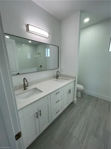 Bathroom with walk in shower, recessed lighting, and double vanity