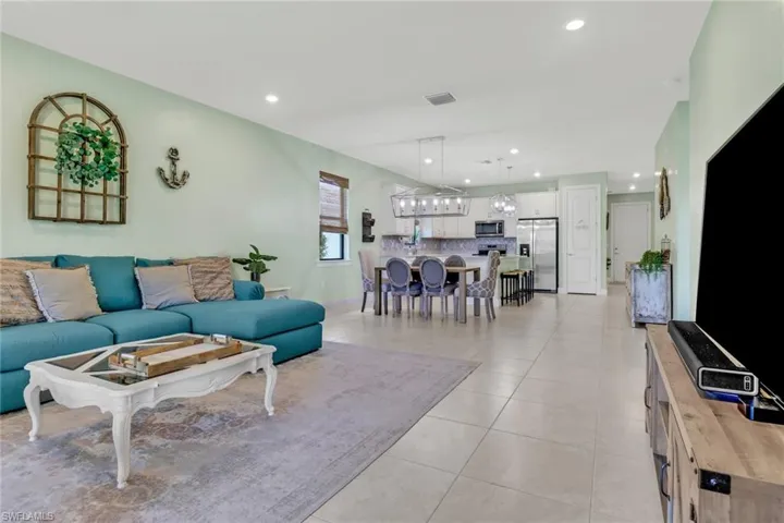 Living room with light tile patterned flooring and recessed lighting