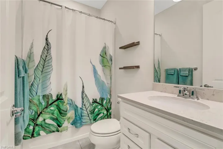 Full bathroom with shower / tub combo, tile patterned flooring, vanity, and toilet