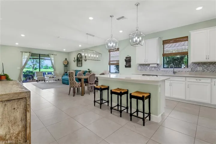 Kitchen featuring open floor plan, light countertops, white cabinetry, and a center island