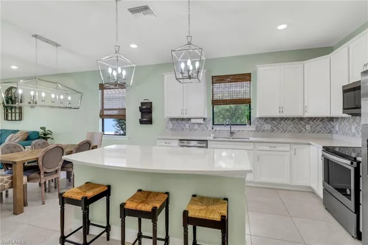 Kitchen featuring light countertops, a center island, white cabinetry, and stainless steel appliances