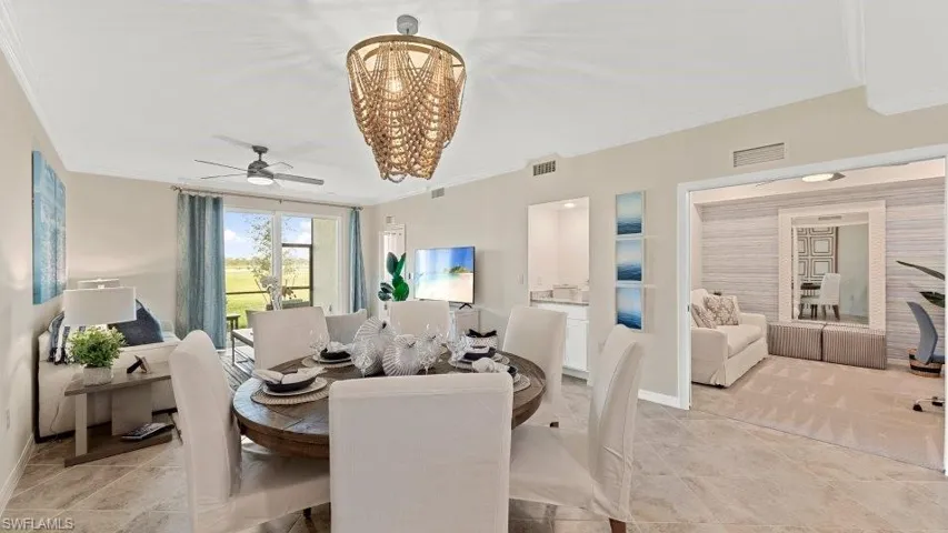 Dining space featuring ornamental molding, ceiling fan, a chandelier, light tile patterned floors, and baseboards