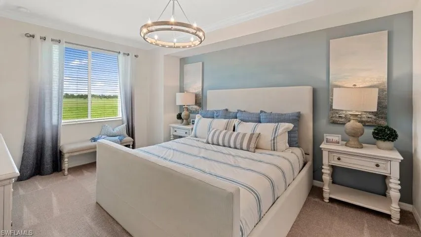 Bedroom with light colored carpet, a chandelier, and ornamental molding