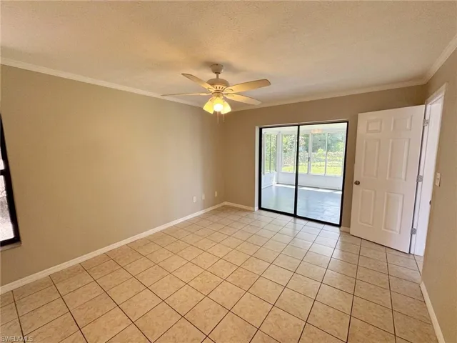 Master bedroom featuring ceiling fan, light tile patterned floors, and a textured ceiling