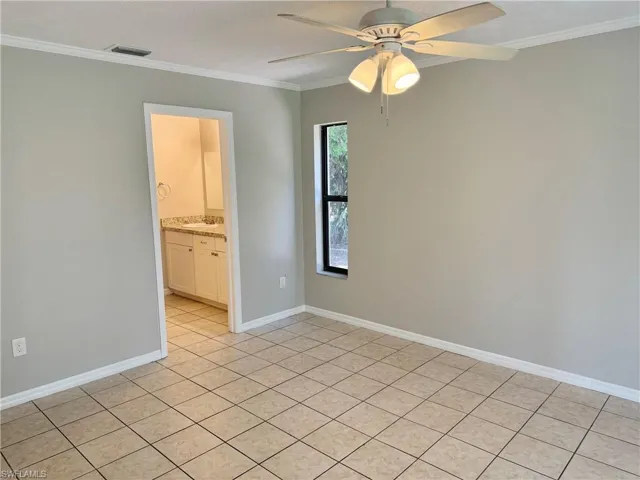 Tiled master bedroom  featuring ceiling fan and ornamental molding