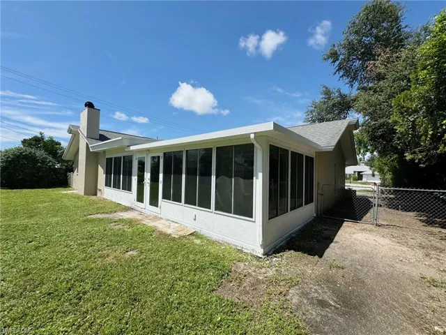 View of side of property with a yard and a sunroom