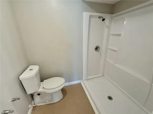 Master bathroom with toilet, tile patterned floors, and walk in shower