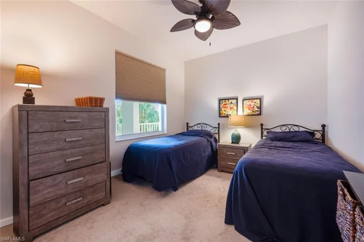 Bedroom with light carpet and a ceiling fan