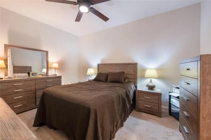 Bedroom with light colored carpet and a ceiling fan