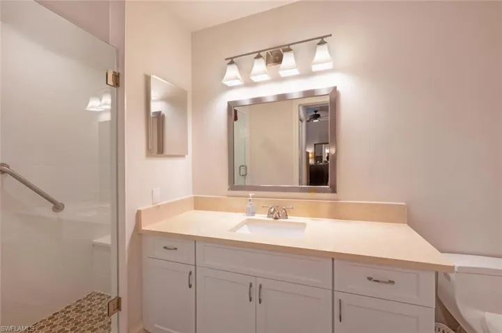 Full bath with a shower stall and vanity