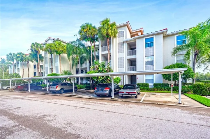 View of apartment building / complex with covered parking