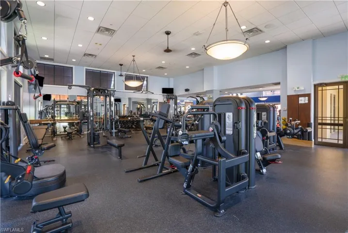 Exercise room featuring a towering ceiling and a drop ceiling