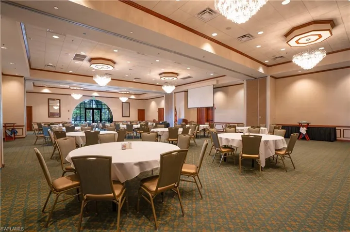 Carpeted dining room with ornamental molding, a tray ceiling, and an inviting chandelier