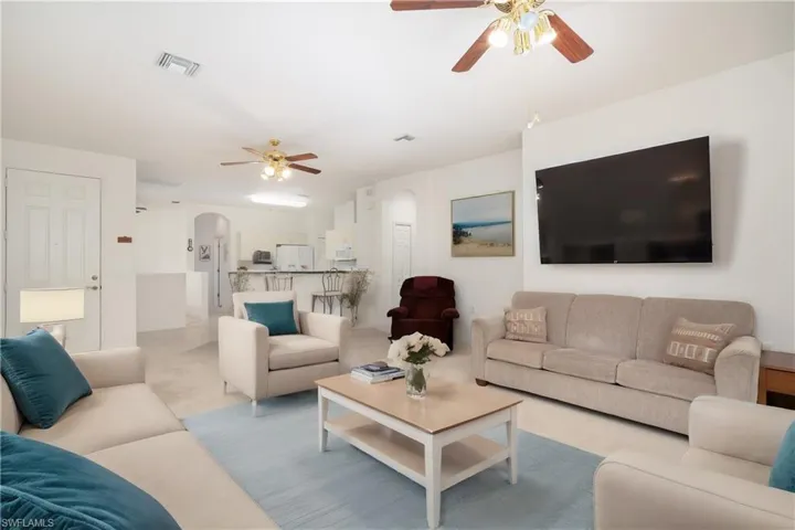 Virtual Staged Living room with light tile flooring and ceiling fan