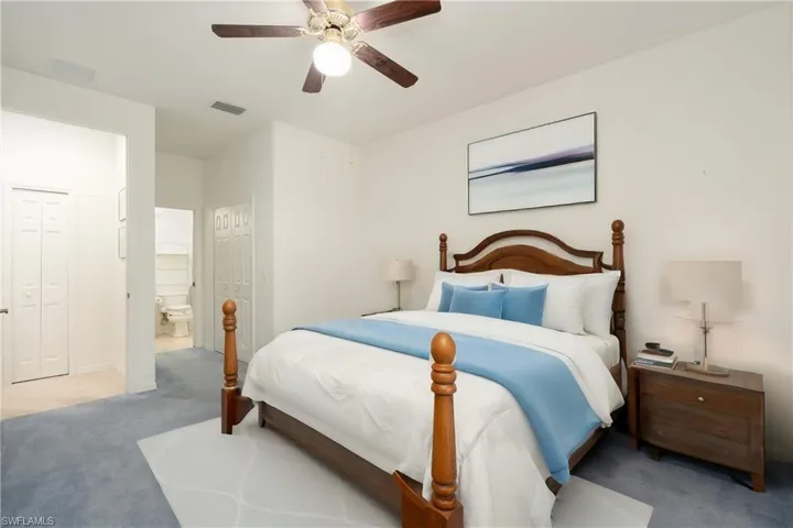 Carpeted bedroom featuring ceiling fan, a closet, and connected bathroom