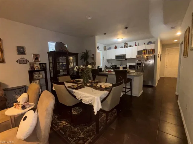 Dining space with dark tile patterned floors and baseboards
